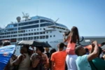 Người dân Cuba chào đón các hành khách trên du thuyền "The Adonia" tại cảng La Habana. (Ảnh: AFP/TTXVN)