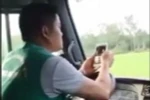 Tài xế hãng xe buýt Khanh Quỳnh vừa lái xe vừa lướt điện thoại. (Ảnh: TTXVN phát)