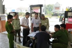 Lực lượng chức năng lập biên bản một cây xăng có gắn chíp gian lận. (Ảnh: TTXVN)