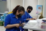 Đoàn thanh niên phường Cống Vị tự làm kính chắn giọt bắn trang bị cho các lực lượng tham gia phòng, chống dịch COVID-19 trên địa bàn. (Ảnh: TTXVN)