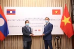 Thứ trưởng Ngoại giao Nguyễn Quốc Dũng (bên phải) trao biểu trưng thiết bị y tế cho Đại sứ Lào tại Việt Nam Sengphet Houngboungnuang. (Ảnh: Dương Giang/TTXVN)