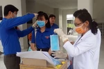 Phát khẩu trang y tế miễn phí cho sinh viên. (Ảnh: Lê Sen/TTXVN)