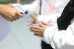 Nhân viên khu vui chơi của 1 trung tâm thương mại kiểm tra nhiệt độ và tẩy trùng vệ sinh để phòng ngừa virus corona. (Ảnh: Thành Đạt/TTXVN)