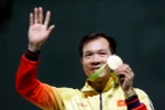 Xạ thủ Hoàng Xuân Vinh cùng tấm huy chương Vàng lịch sử. (Nguồn: EPA/TTXVN)