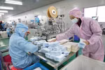 Công nhân may khẩu trang y tế tại một nhà máy ở Vũ Hán, Trung Quốc. (Nguồn: THX/TTXVN)