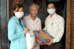 Trao quà hỗ trợ cho gia đình thuộc hộ nghèo có hoàn cảnh khó khăn bị ảnh hưởng do dịch COVID-19. (Ảnh: Trần Lê Lâm/TTXVN)
