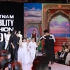 Cặp vợ chồng "tí hon" nhưng truyền cảm hứng mạnh mẽ Nguyễn Văn Hùng và Lê Thị Diễm My (đều 37 tuổi) cùng các nhà tạo mẫu của chương trình. Anh chị được thiết kế trang phục trắng muốt tinh khôi, nổi bật trên sàn diễn. (Ảnh: Minh Anh/Vietnam+)