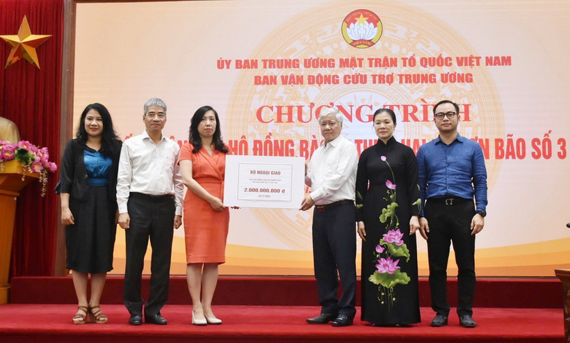 Chủ tịch Ủy ban Trung ương Mặt trận Tổ quốc Việt Nam Đỗ Văn Chiến tiếp nhận bảng tượng trưng số tiền từ Thứ trưởng Bộ Ngoại giao, Chủ nhiệm Ủy ban Nhà nước về người Việt Nam ở nước ngoài Lê Thị Thu Hằng. (Ảnh: TTXVN phát)
