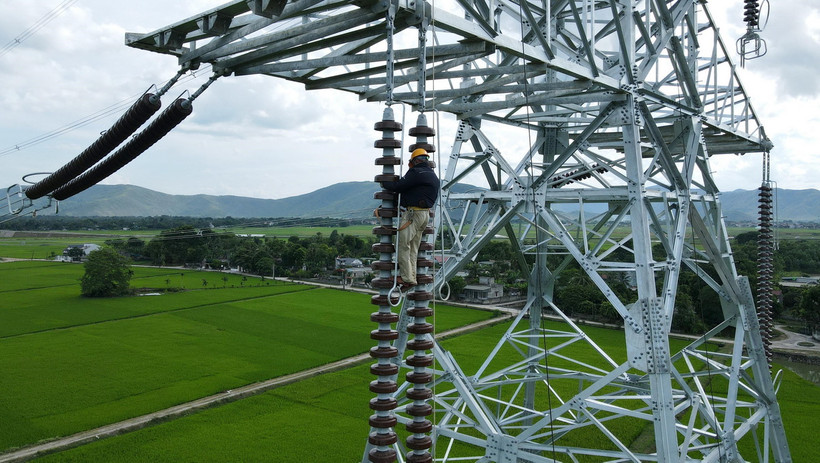 Nhà thầu thi công đường dây 500kV mạch 3 cố gắng lắp sứ và đưa dây lên cột đúng kế hoạch đề ra. (Ảnh: Việt Hoàng/TTXVN)