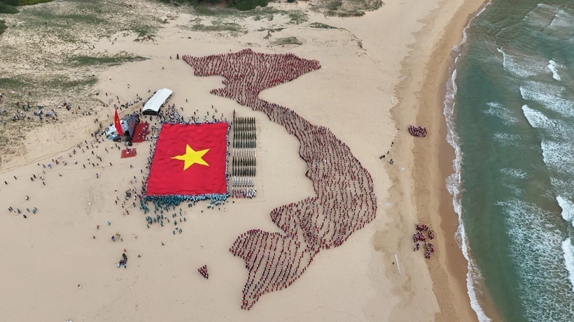 Đoàn viên thanh niên và học sinh tỉnh Phú Yên xếp hình bản đồ đất nước với hai quần đảo Hoàng Sa và Trường Sa bên cạnh cờ Tổ quốc. (Ảnh: TTXVN phát)