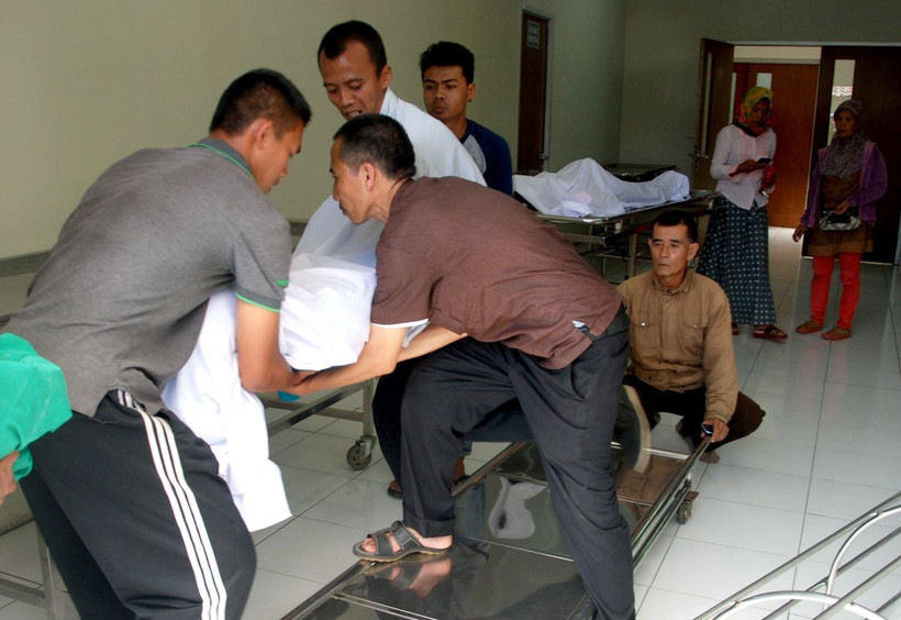  Chuyển thi thể nạn nhân tử vong do ngộ độc rượu. (Ảnh minh họa: AFP/TTXVN)