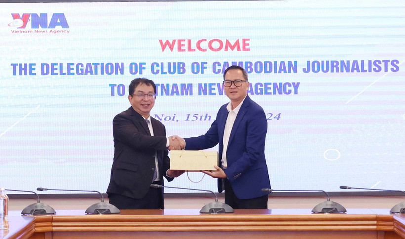 Phó Tổng Giám đốc TTXVN Nguyễn Tuấn Hùng và Chủ tịch Câu lạc bộ Các nhà báo Campuchia, Puy Kea trao đổi quà lưu niệm. (Ảnh: Phương Hoa/TTXVN)