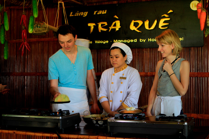 Du khách quốc tế trải nghiệm làm bánh xèo ở Hội An. (Ảnh: Mai Mai/Vietnam+)