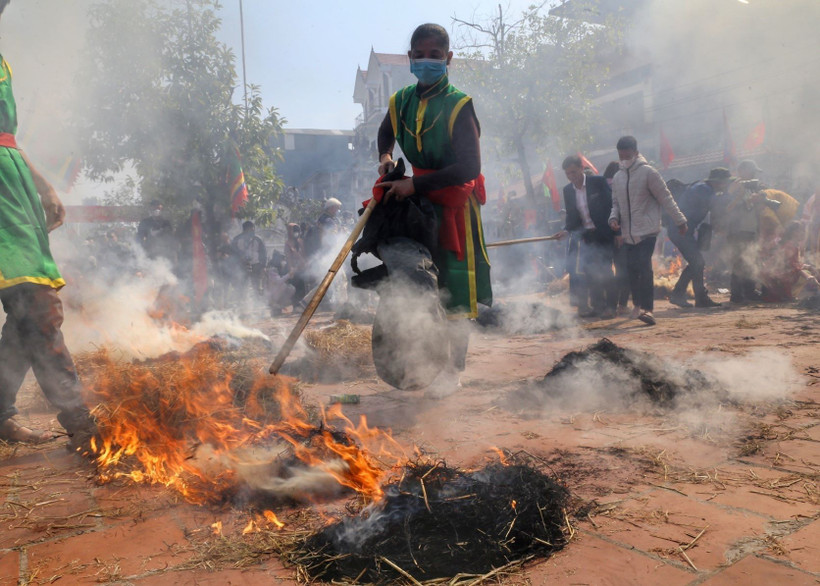 Các nồi cơm được ủ trong đống than rơm để cơm chín đều. (Ảnh: Tuấn Đức/TTXVN)
