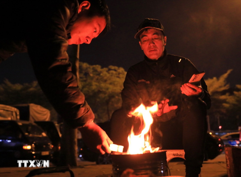 Người dân đốt lửa sưởi ấm trong đêm Đông. (Nguồn: TTXVN)