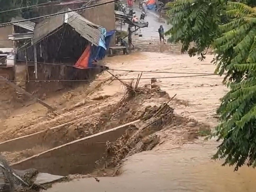 Nước suối dâng cao đã gây ngập qua đập tràn bản Xuân Thành khiến giao thông bị chia cắt. (Ảnh: TTXVN phát)