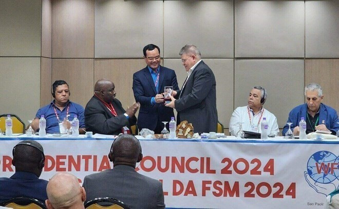 Chủ tịch Tổng Liên đoàn Lao động Việt Nam Nguyễn Đình Khang tặng quà lưu niệm Ban lãnh đạo Liên hiệp Công đoàn Thế giới. (Ảnh: TTXVN phát)