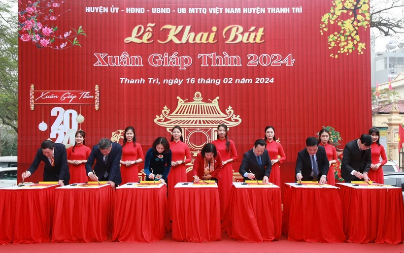 Các đại biểu thành phố Hà Nội thực hiện nghi thức khai bút. (Ảnh: TTXVN phát)