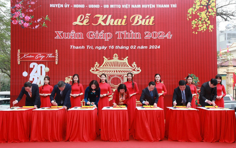 Các đại biểu thành phố Hà Nội thực hiện nghi thức khai bút. (Ảnh: TTXVN phát)