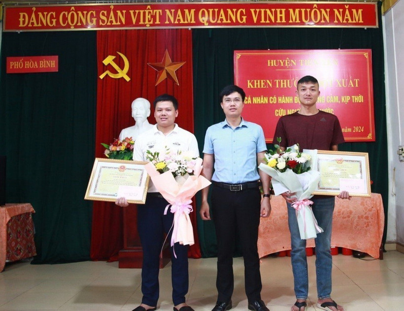 Ủy ban Nhân dân huyện Tiên Yên (Quảng Ninh) biểu dương, khen thưởng đột xuất 2 nam thanh niên dũng cảm cứu người. (Ảnh: TTXVN phát)