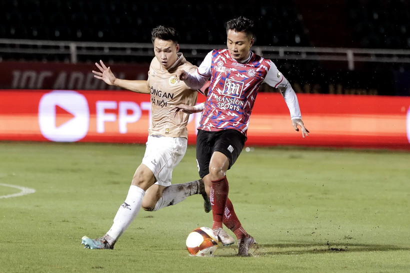 Pha tranh bóng giữa các cầu thủ Câu lạc bộ Thành phố Hồ Minh (áo đỏ chấm trắng) và Câu lạc bộ Công an Hà Nội (áo hồng phấn). (Ảnh: Thanh Vũ/TTXVN)