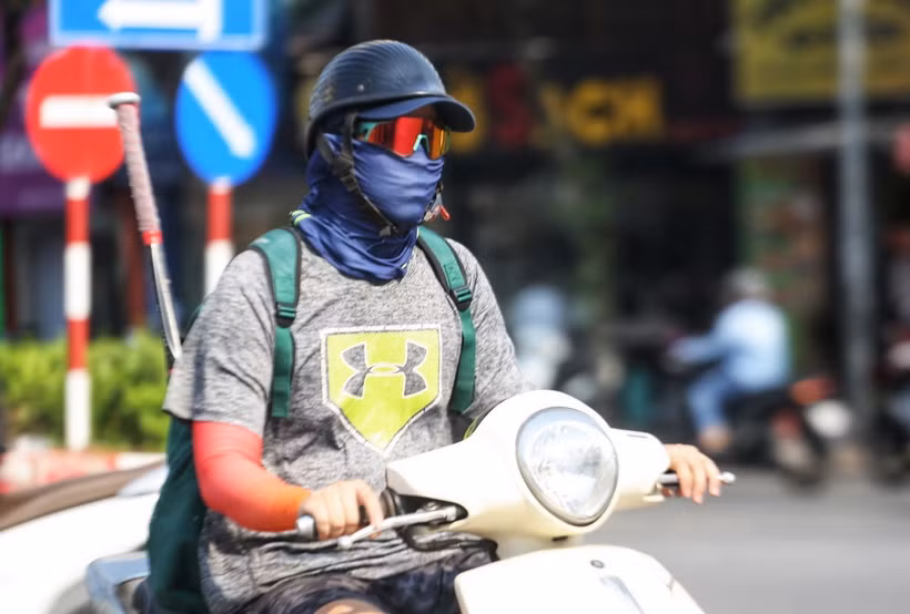 Người dân bịt kín khi ra đường trong ngày nắng nóng để đảm bảo sức khỏe. (Ảnh: TTXVN phát)