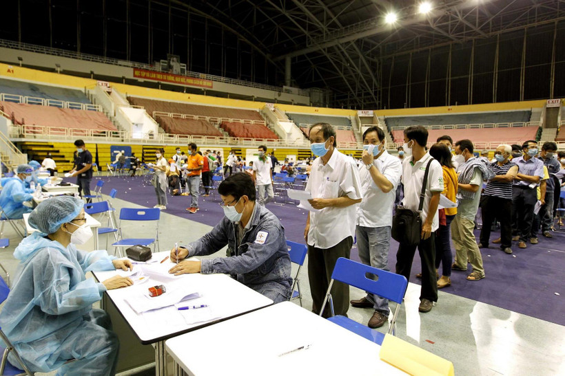 Người lao động xếp hàng chờ thực hiện các thủ tục khai báo y tế trước khi tiêm vaccine phòng COVID-19 tại Nhà thi đấu Phú Thọ. (Ảnh: Thanh Vũ/TTXVN)