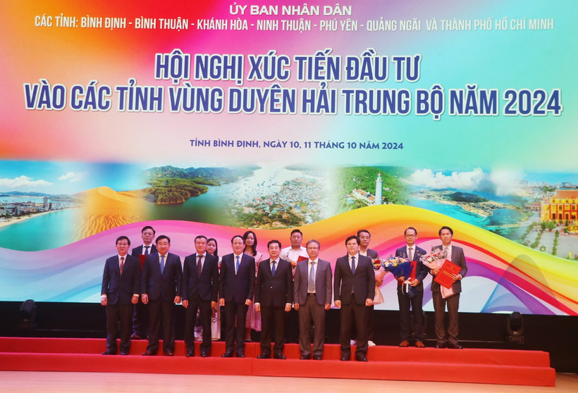 Lãnh đạo Ủy ban Nhân dân tỉnh Bình Định trao tặng quyết định chủ trương, giấy chứng nhận đầu tư cho các doanh nghiệp. (Ảnh: Sỹ Thắng/TTXVN)