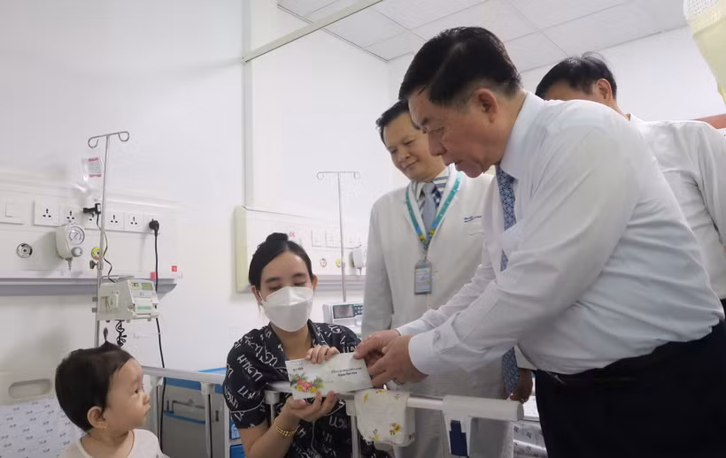 Trưởng Ban Tuyên giáo Trung ương Nguyễn Trọng Nghĩa tặng quà cho bệnh nhi điều trị tại Bệnh viện Nhi đồng Thành phố Hồ Chí Minh. (Ảnh: Đinh Hằng/TTXVN)