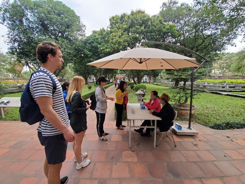 Du khách quốc tế thăm quan Văn Miếu trước ngày điểm đến này đóng cửa phòng dịch. (Ảnh: Bùi Huy Hoàng/Vietnam+)