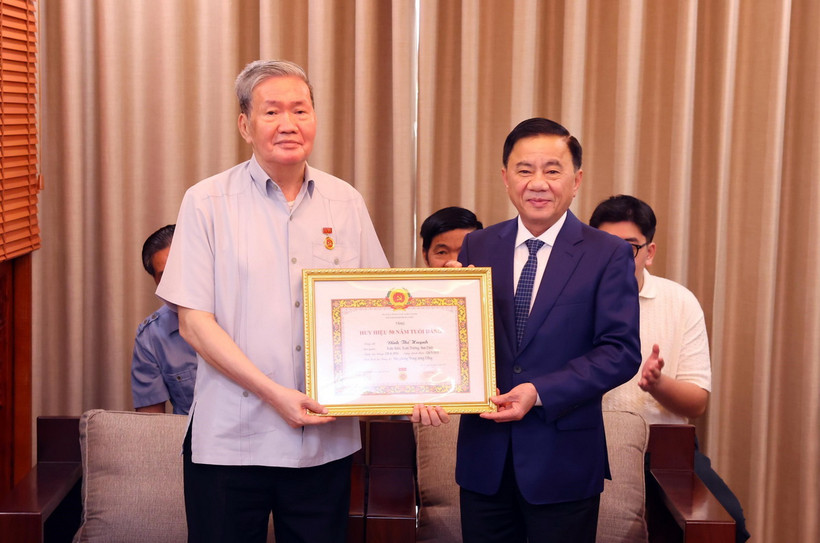 Thường trực Ban Bí thư, Chủ nhiệm Ủy ban Kiểm tra Trung ương Trần Cẩm Tú trao Huy hiệu 50 năm tuổi Đảng tặng ông Đinh Thế Huynh. (Ảnh: Phạm Kiên/TTXVN)