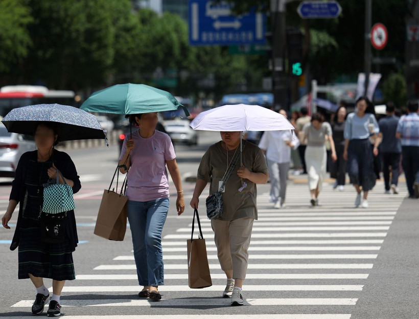 Người dân che ô tránh nắng nóng trên đường phố tại Seoul, Hàn Quốc. (Ảnh: Yonhap/TTXVN)