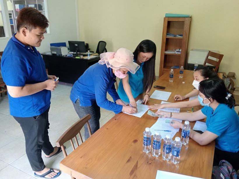 Đại diện Liên đoàn Lao động tỉnh Bình Dương hỗ trợ công nhân của Công ty Hoàng Sinh gặp khó khăn. (Ảnh: TTXVN phát)