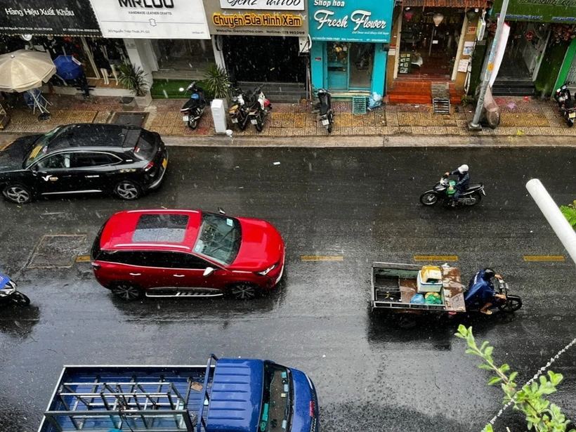 Các phương tiện di chuyển trong cơn mưa trên đường Nguyễn Thiện Thuật (quận 3, Thành phố Hồ Chí Minh). (Ảnh: Thanh Vũ/TTXVN)