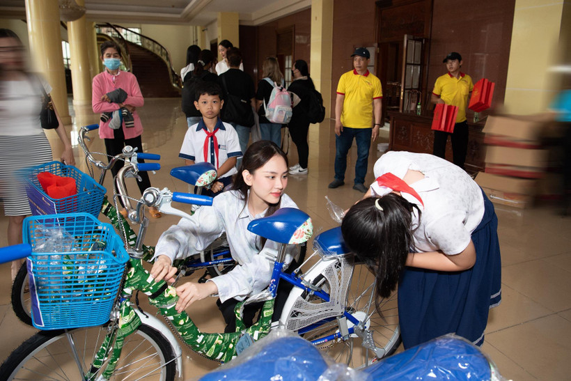 Hoa hậu Mai Phương trao xe đạp cho các em học sinh có hoàn cảnh khó khăn. (Ảnh: CTV/Vietnam+)
