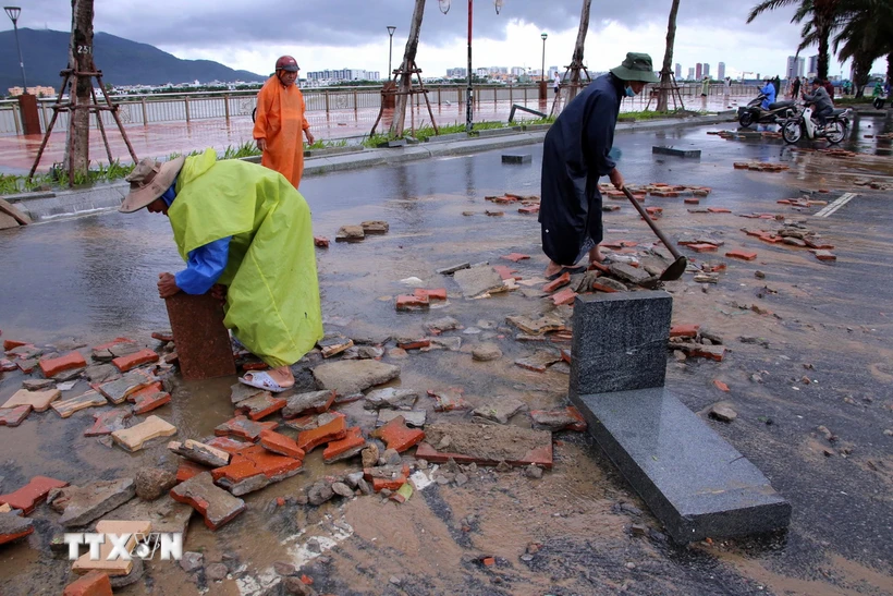 Các đơn vị chức năng thành phố Đà Nẵng dọn vệ sinh môi trường tại khu vực bị hư hỏng nặng trên đường Như Nguyệt. (Ảnh: Trần Lê Lâm/TTXVN)