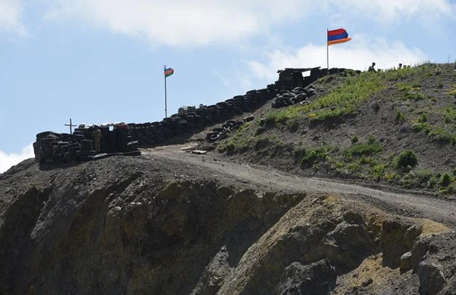 Quốc kỳ Azerbaijan (trái) và quốc kỳ Armenia tại trạm kiểm soát biên giới giữa hai nước ở làng Sotk (Armenia). (Ảnh: AFP/TTXVN) 