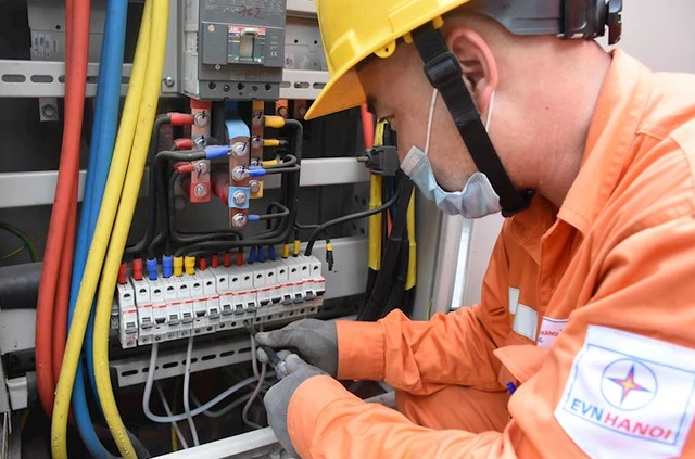 Nhân viên EVNHANOI kiểm tra tình trạng vận hành của thiết bị điện. (Ảnh: PV/Vietnam+)