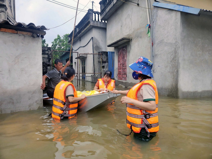 Các cô giáo trường mầm non Thanh Nghị (huyện Thanh Liêm) tổ chức nấu cơm và đi phát cho người dân trong lũ. (Ảnh: Đại Nghĩa/TTXVN)