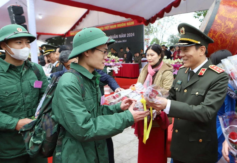 Thượng tướng Lương Tam Quang, Ủy viên Trung ương Đảng, Thứ trưởng Bộ Công an tặng hoa chúc mừng các tân binh. (Ảnh: Thế Duyệt/TTXVN)