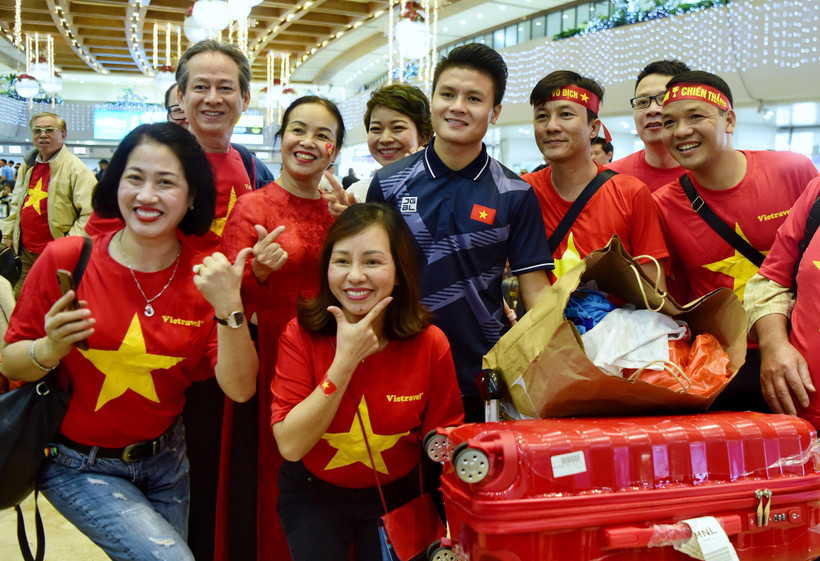 Cổ động viên Việt Nam chụp ảnh với cầu thủ Quang Hải. (Ảnh: CTV/Vietnam+)
