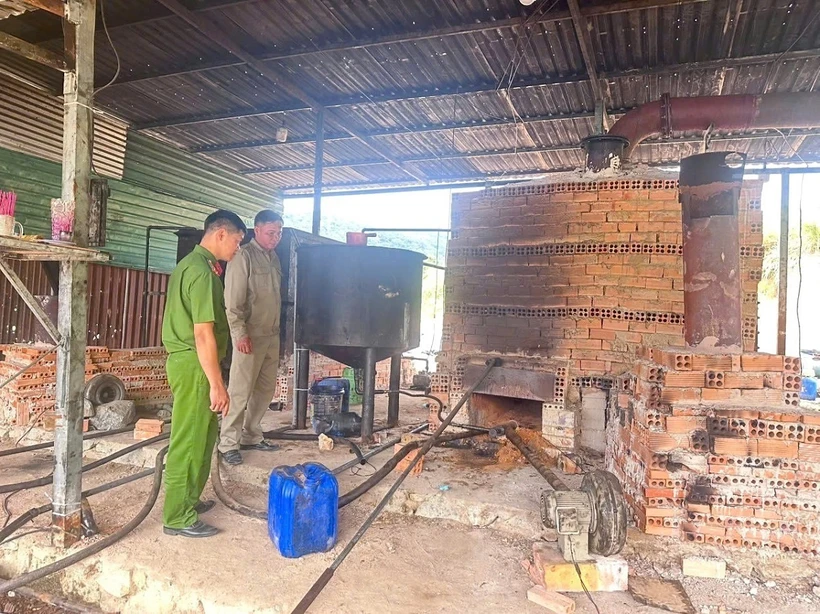 Lực lượng công an kiểm tra hệ thống máy vận hành để tái chế nhớt thải trái phép tại thôn Đaguri, xã Đa Mi, huyện Hàm Thuận Bắc (Bình Thuận). (Ảnh TTXVN phát)