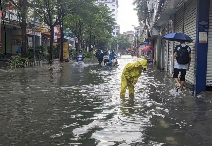 Một số điểm trên phố Triều Khúc bị ngập sâu, giao thông khó khăn. (Ảnh: TTXVN phát)
