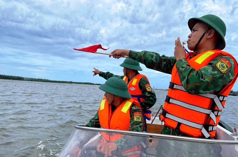 Cán bộ, chiến sỹ Đồn Biên phòng Lý Hòa (Bộ đội Biên phòng Quảng Bình) giúp ngư dân xã Đức Trạch, huyện Bố Trạch đưa thuyền lên bờ tránh trú. (Ảnh: TTXVN phát) 