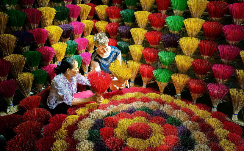 Du khách quốc tế trải nghiệm ở làng nghề làm hương. (Ảnh: Trần Hữu Minh/Vietnam+)