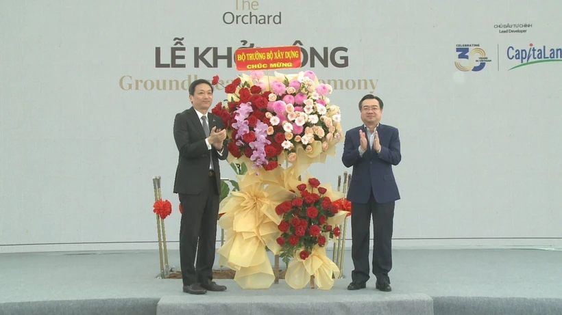 Bộ trưởng Bộ Xây dựng Nguyễn Thanh Nghị (phải) tặng hoa chúc mừng. (Ảnh: Huyền Trang/TTXVN)