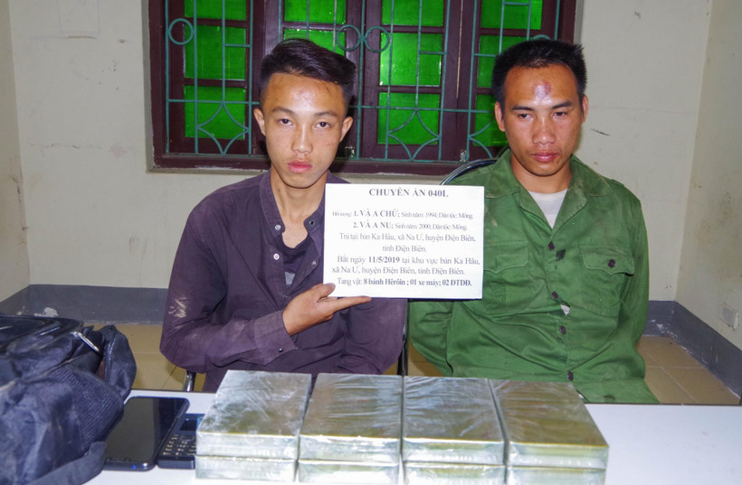 Hai đối tượng cùng tang vật tại cơ quan điều tra. (Ảnh: Xuân Tư/TTXVN)