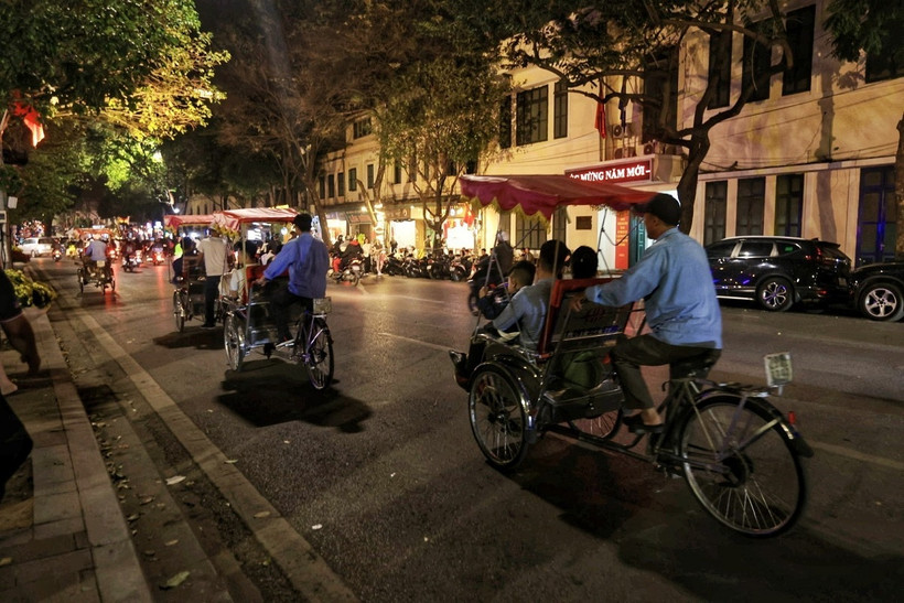 Nhiều gia đình ngắm phố phường Hà Nội trên những chuyến xích lô. (Ảnh: Tuấn Anh/TTXVN)