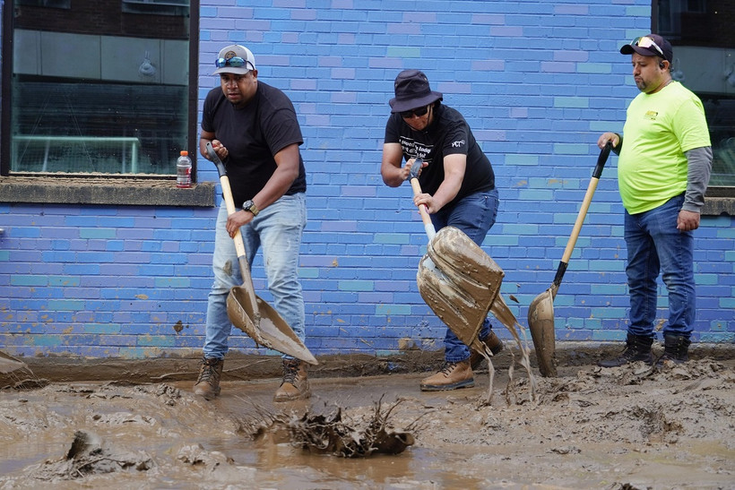 Người dân dọn bùn sau khi bão Helene quét qua ở Asheville, bang North Carolina, Mỹ ngày 1/10/2024. (Ảnh: Kyodo/TTXVN)