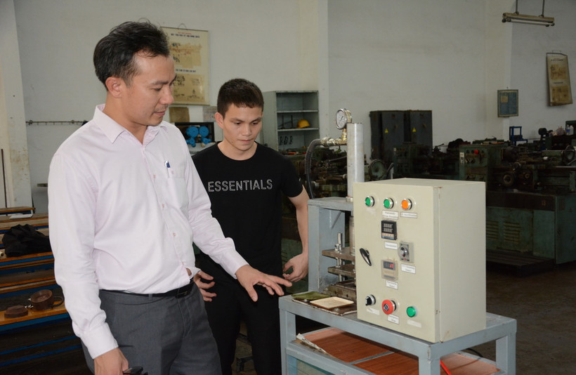 Tiến sỹ Bùi Hệ Thống, Giảng viên khoa Cơ khí, trường Đại học Sư Phạm Kỹ thuật-Đại học Đà Nẵng hướng dẫn sinh viên nghiên cứu hoàn thiện "Máy ép chén đĩa từ vật liệu thân thiện môi trường." (Ảnh: Văn Dũng/TTXVN)